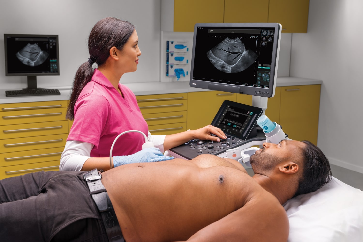 Eine medizinische Fachkraft führt eine Ultraschalluntersuchung des Abdomens an einem männlichen Patienten durch, der auf einer Untersuchungsliege in einer medizinischen Klinik liegt, in der auch minimalinvasive Verfahren der Karpaltunnelspaltung angeboten werden.