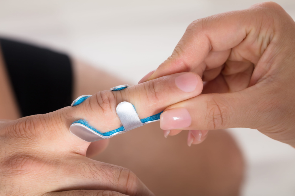 Seitenbandruptur der Fingergelenke Eine Hand bringt eine Metallschiene an einem Finger an, um ihn zu stützen und zu immobilisieren, möglicherweise bei einer Verletzung wie einer Verstauchung, einem Bruch oder einer Seitenbandruptur der Finger.